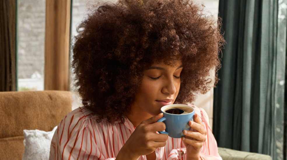 Antioxidants in coffee Woman takes in the aroma of her coffee