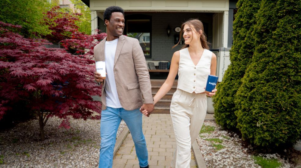 A young couple walks with coffee - Does Coffee Bring Up Blood Pressure